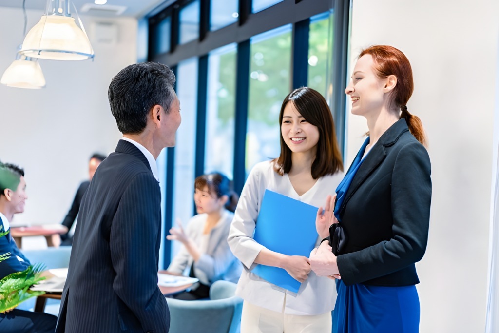 A female interpreter is providing a simultaneous translation for the Japanese business person and a female business person from the foreign company