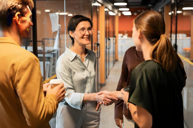 女性通訳がクライアントの同僚とオフィスの廊下で握手している